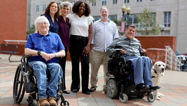 Group photo of six adult members of the Disability Studies minor committee. Also includes a white service dog.
