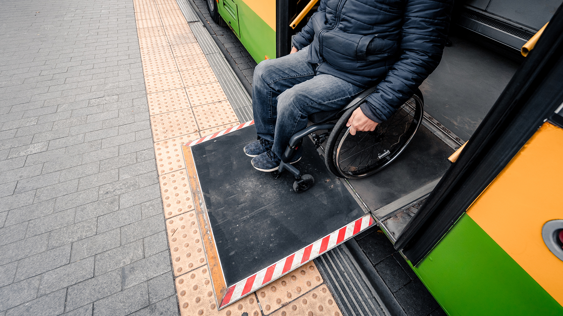 Person with a physical disability exits public transport with an