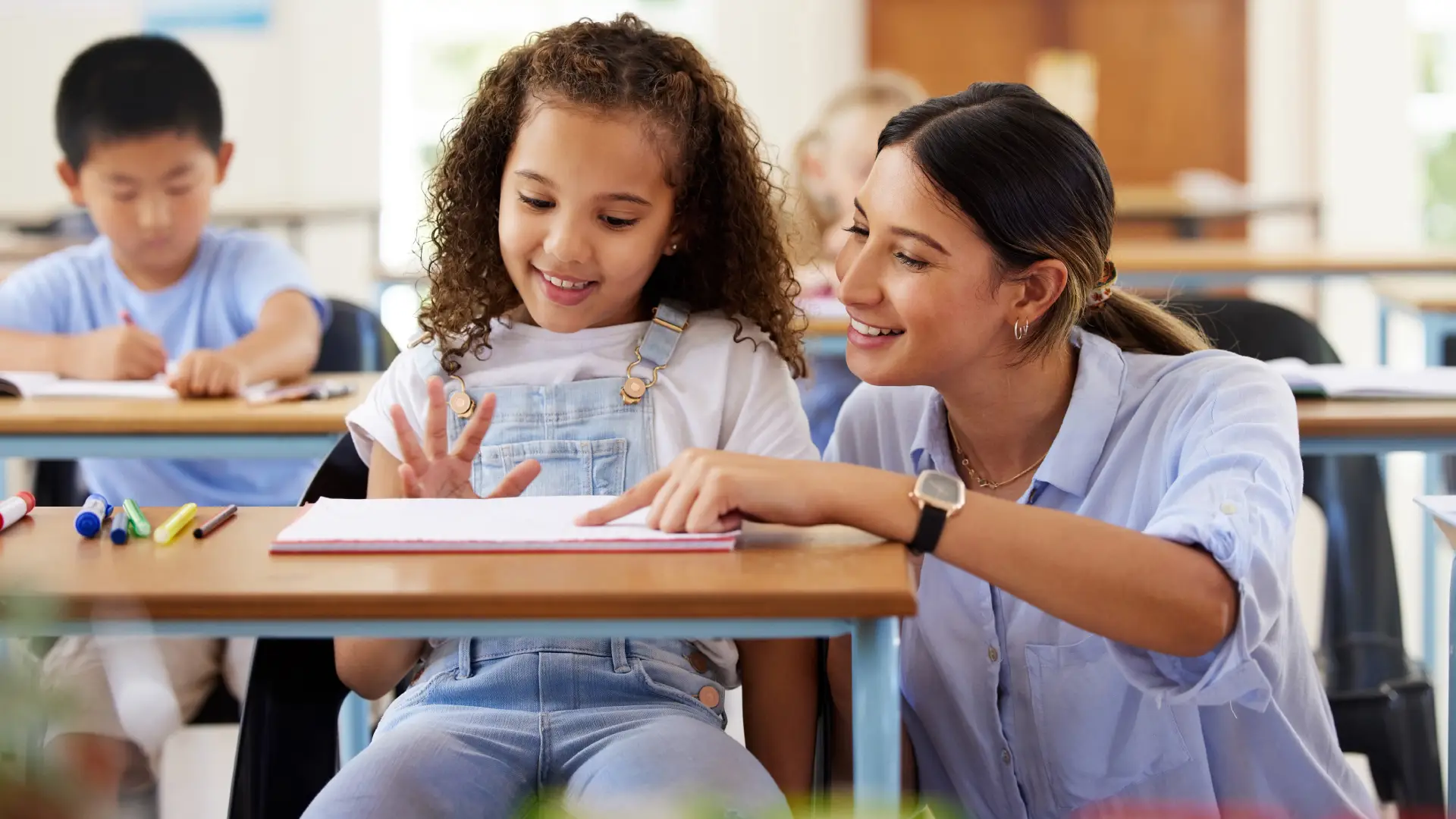 Teacher helping girl in classroom